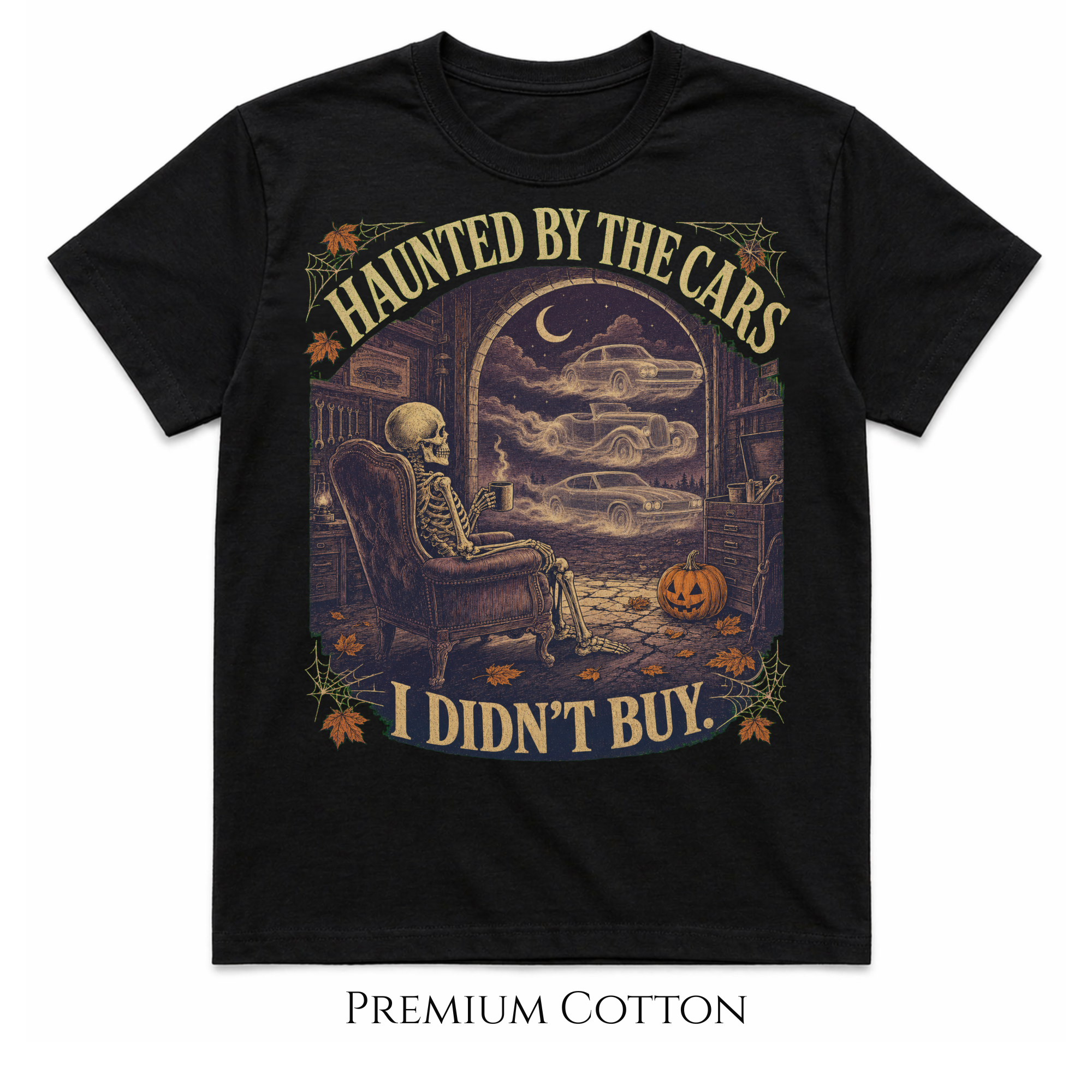 A black short-sleeve graphic T-shirt on a white background, featuring a Halloween-themed illustration of a skeleton sitting in an armchair and viewing parked cars through a window, with the text 'HAUNTED BY THE CARS I DIDN'T BUY.' and decorative autumn accents.