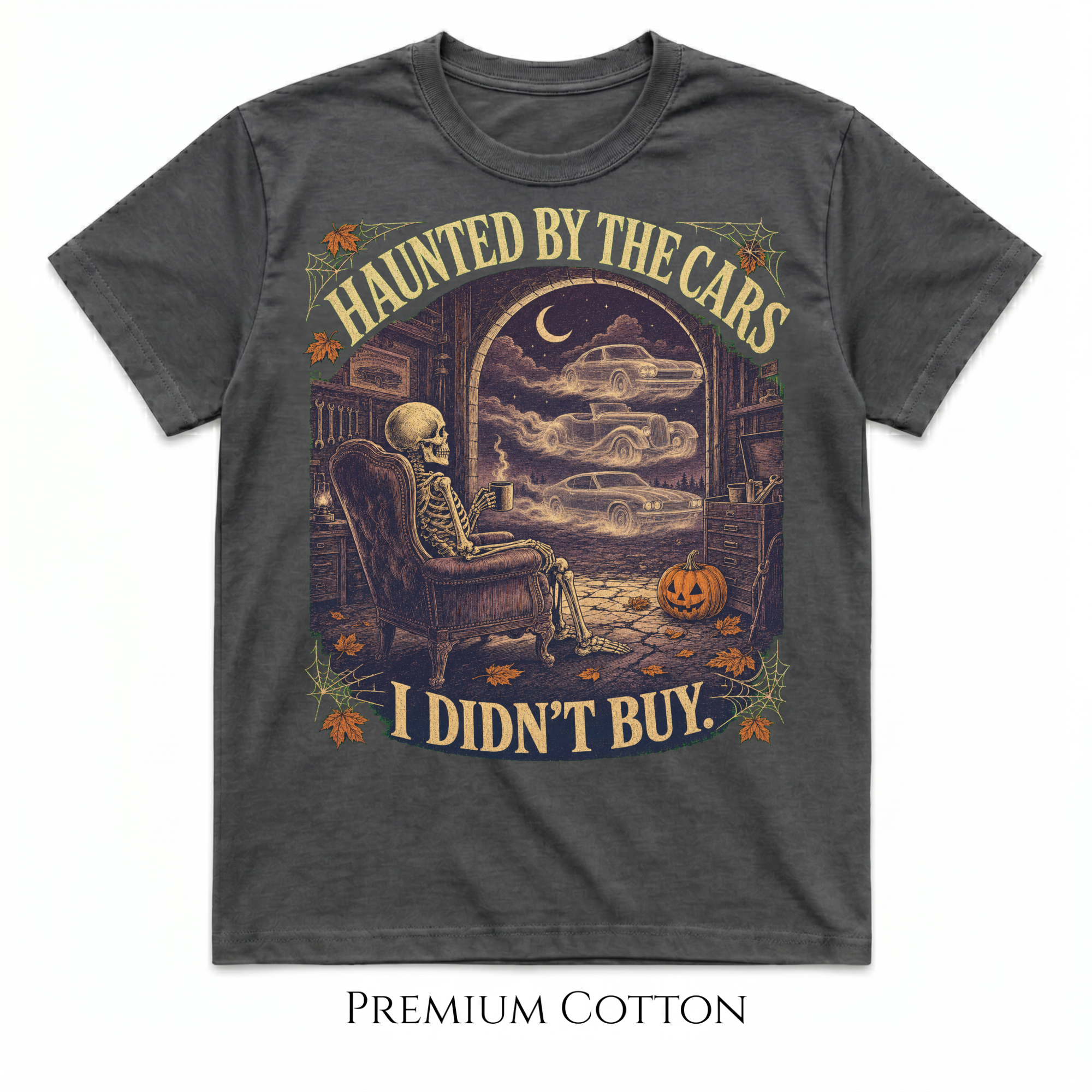 A dark gray heathered graphic t-shirt featuring a Halloween-themed illustration of a skeleton sitting in an armchair with a ghostly car outside an open window. The text reads 'HAUNTED BY THE CARS I DIDN'T BUY.