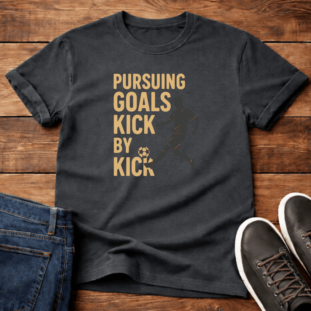 Pursuing Goals T-Shirt in dark gray with a soccer graphic and motivational text.
