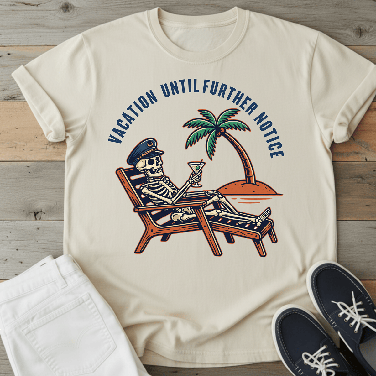 Optimistic Castaway T-Shirt featuring a skeleton relaxing with a drink under a palm tree on a light background.